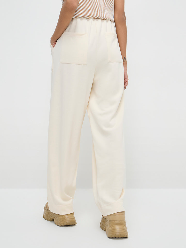 Westside Studiofit Women's Off-White Solid High-Rise Track Pants for Sports Wear Back View
