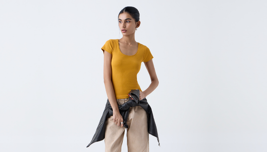 Stylish woman and man with travel bags wearing chic vacation outfits