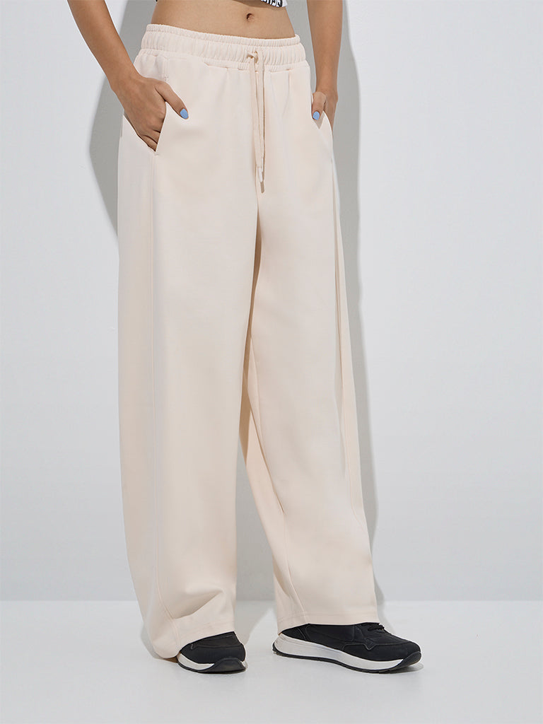 Westside Studiofit Women's Beige Solid High-Rise Cotton Track Pants for Sports Wear Front View