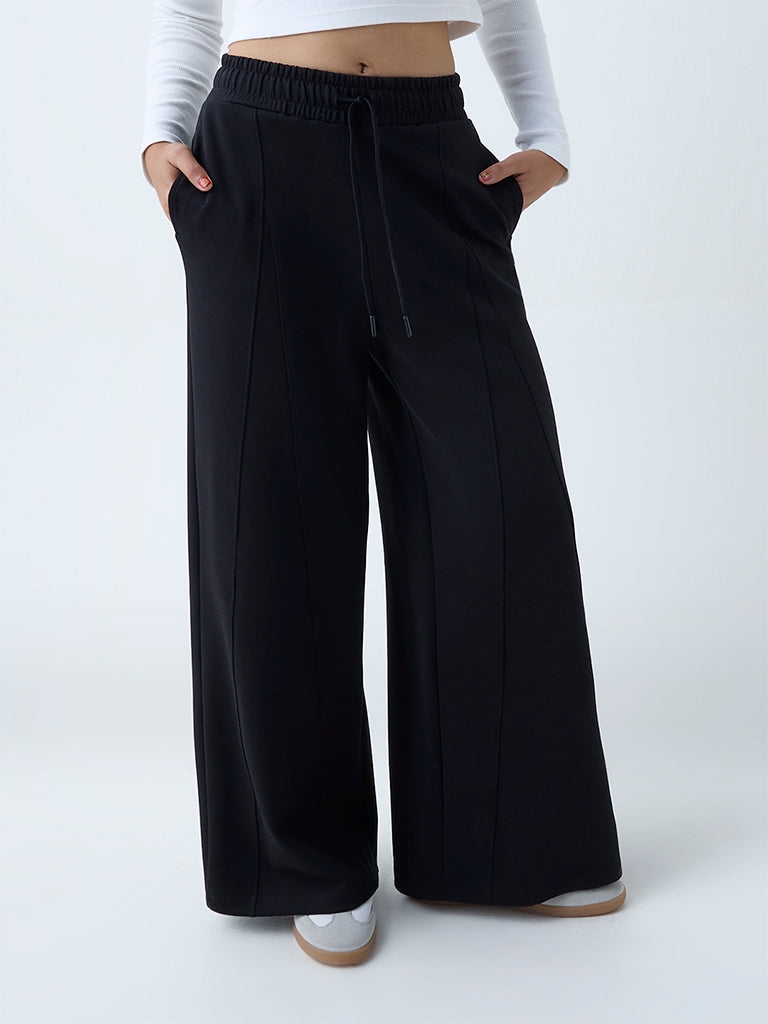 Westside Studiofit Women's Black Solid High-Rise Track Pants for Sports Wear Front View