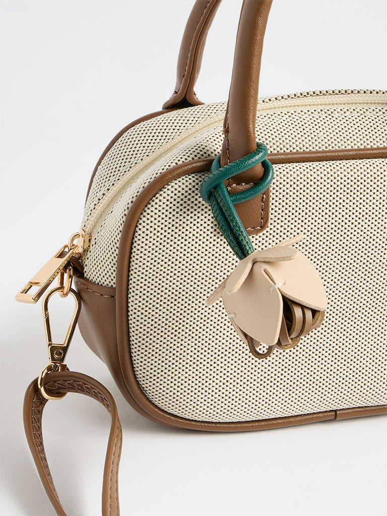 Westside Off-White Textured Sling Bag with a Floral Bag Charm